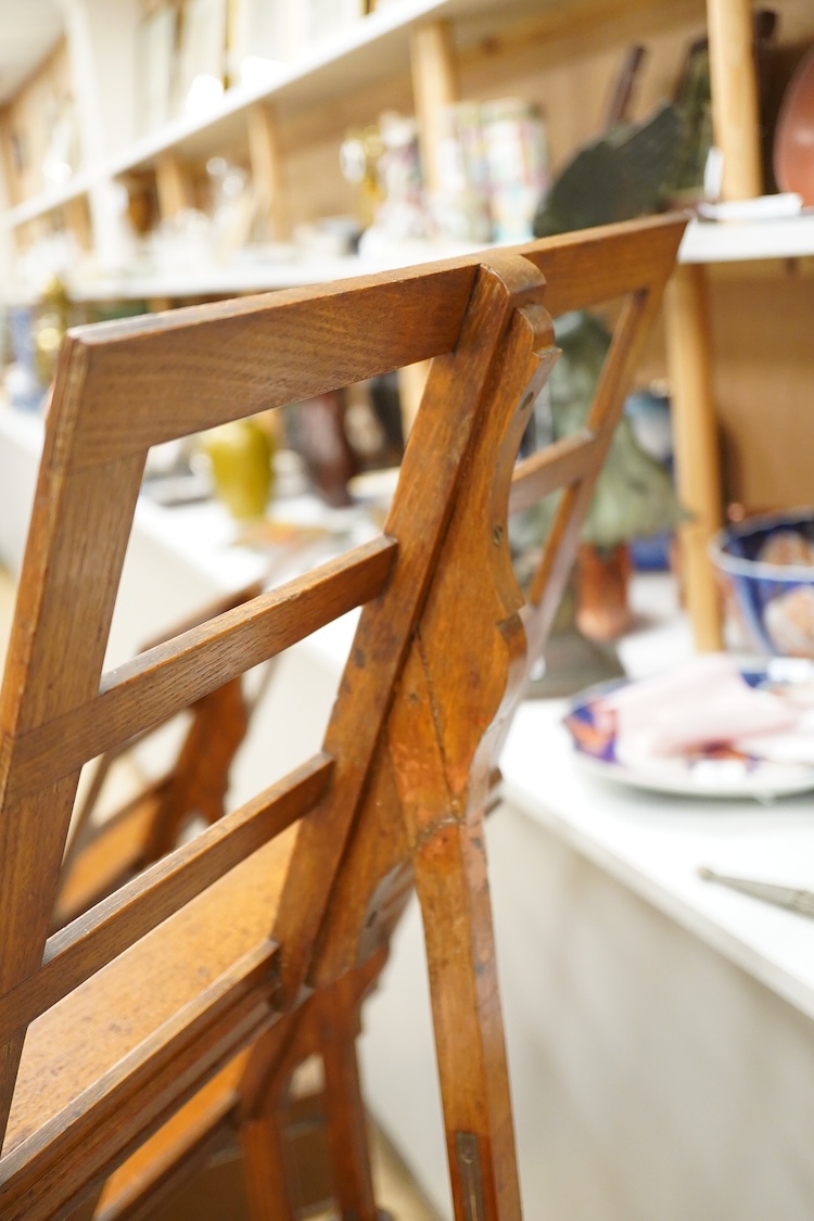A set of three early 20th century oak music stands, all with fluted pedestal supports and tripod legs with brass feet, adjustable height music desks, maximum overall height when extended 137cm, the angle of the desks is